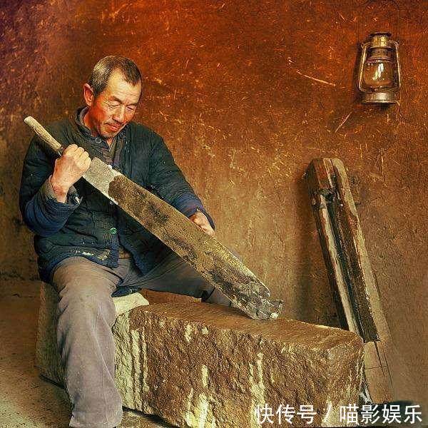 美国人镜头下1985年中国农村老照片,一位大爷正在磨铡草用的铡刀.