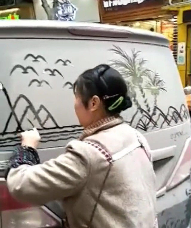 小伙看到大妈在自己车上乱画,准备上前理论,结果却是佩服不已