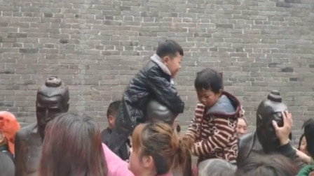奇葩！万名游客“打”秦桧 小朋友骑着秦桧雕像打