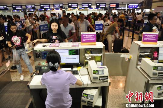 圖為旅客在機場大廳值機. 呂俊明 攝